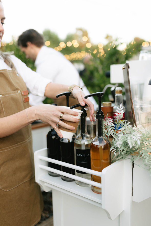 Homegrown barista preparing a drink beside the syrup station