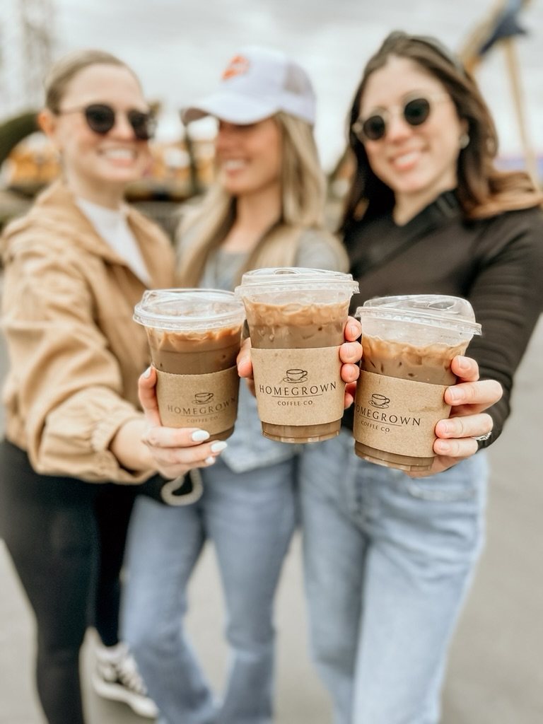 Three guests sharing branded Homegrown iced coffees