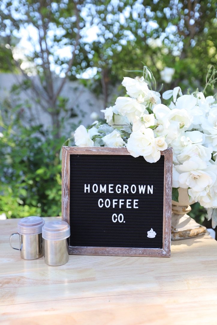 Homegrown Coffee Co. sign framed by white garden roses