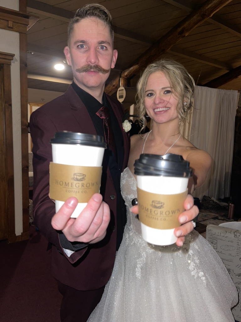 Newlyweds holding Homegrown coffee cups at their reception