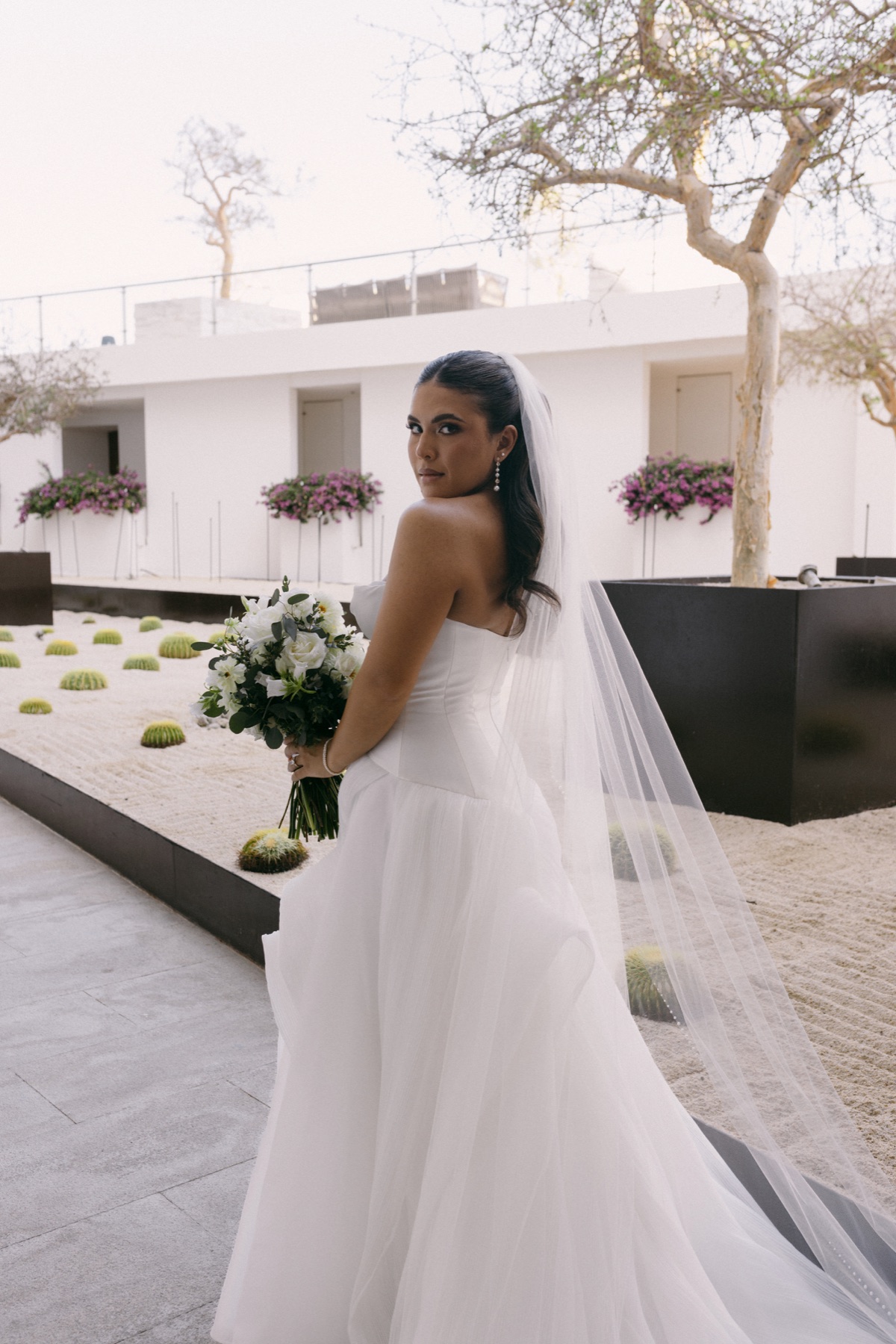 Bride holding a white bouquet in a modern garden